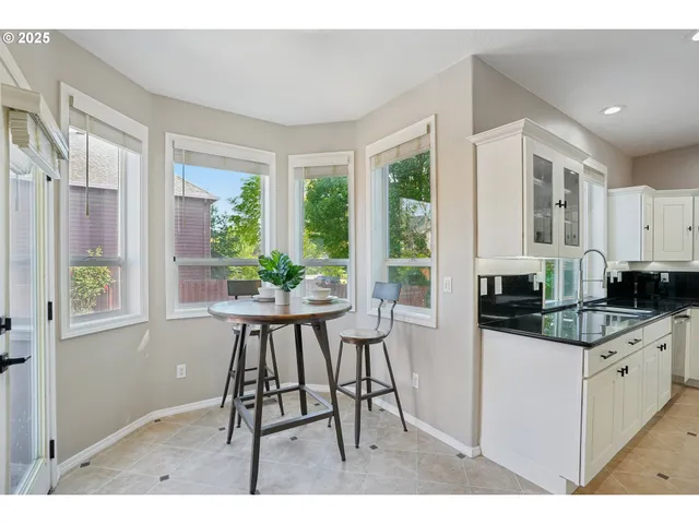 a kitchen with granite countertop a sink and white cabinets