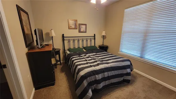 a bedroom with a bed a dresser and a window