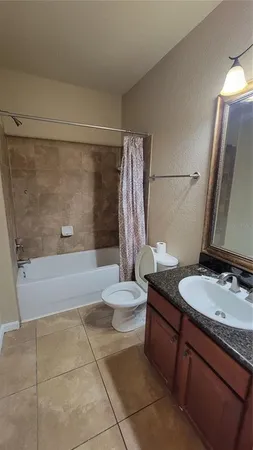 a bathroom with a granite countertop sink toilet a mirror and shower