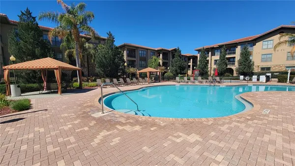 a view of a swimming pool with chairs in patio