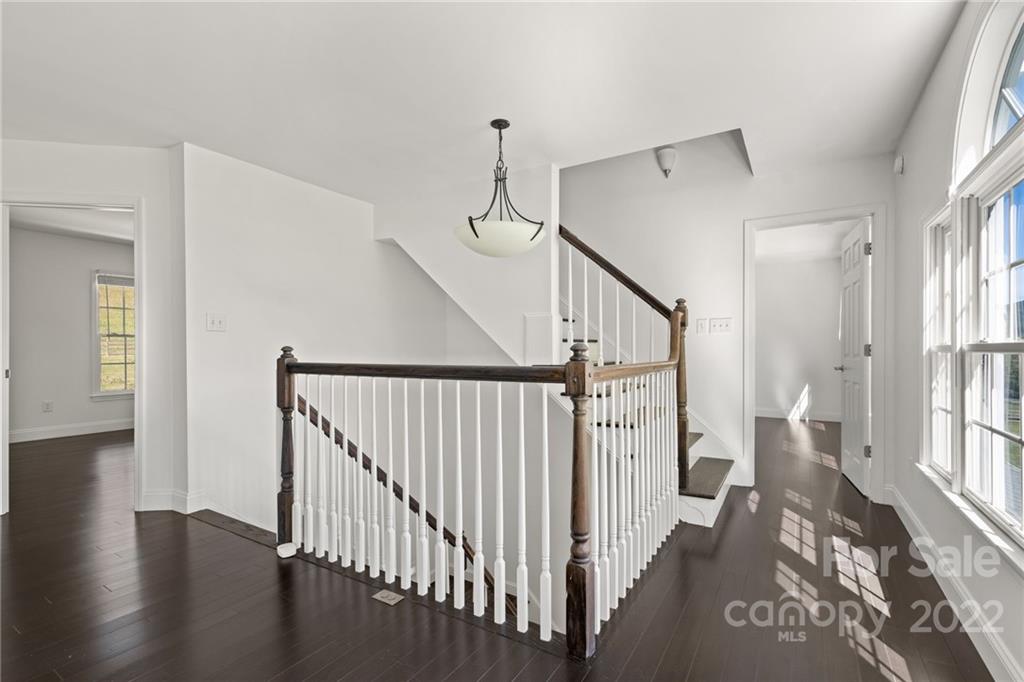 770 Grindstone Road Waynesville, NC 28785 - Photo 27 of 48 a view of staircase with lots of frames on wall and wooden floor