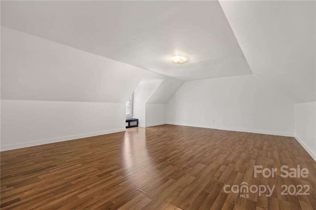770 Grindstone Road Waynesville, NC 28785 - Photo 38 of 48 an empty room with wooden floor and natural light