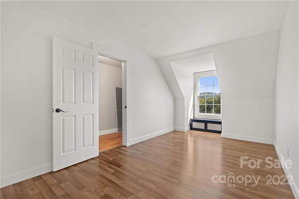 770 Grindstone Road Waynesville, NC 28785 - Photo 39 of 48 an empty room with wooden floor and windows