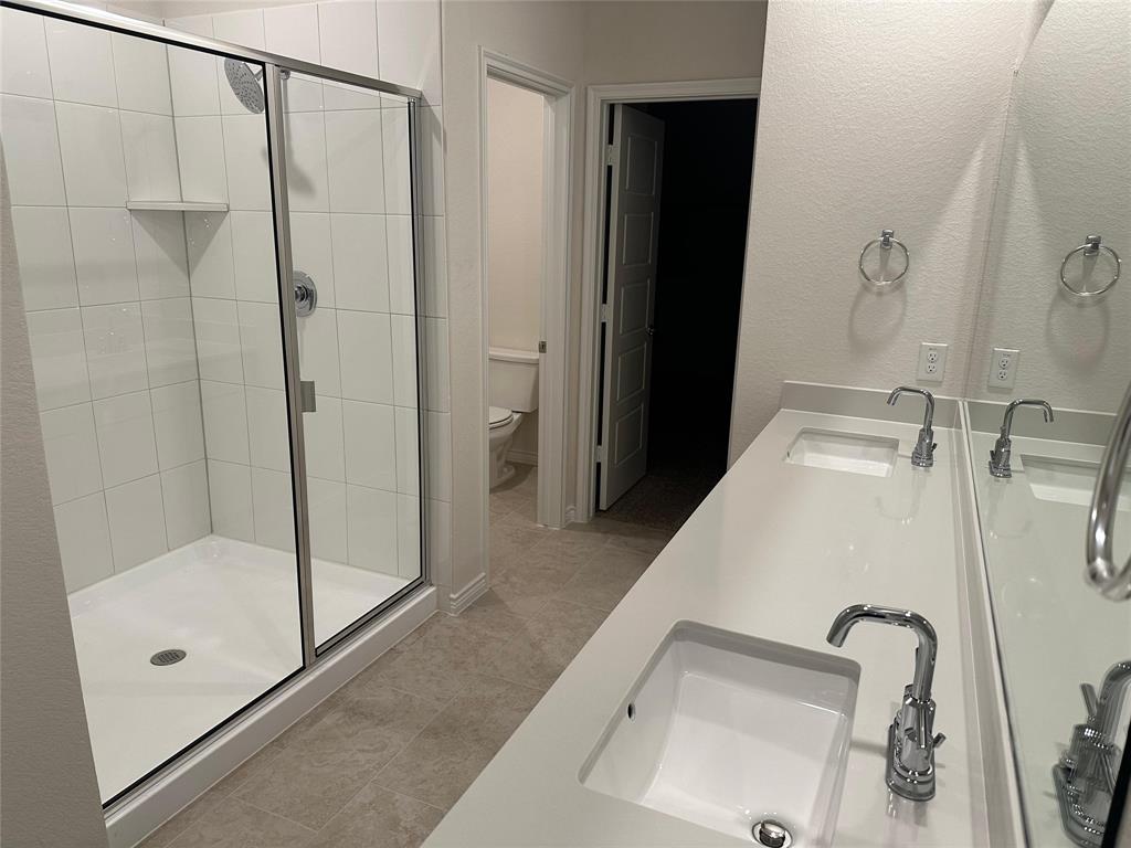 2408 Grapevine Way Celina, TX 75009 - Photo 9 of 20 Full bath with double vanity, a stall shower, and light tile patterned flooring