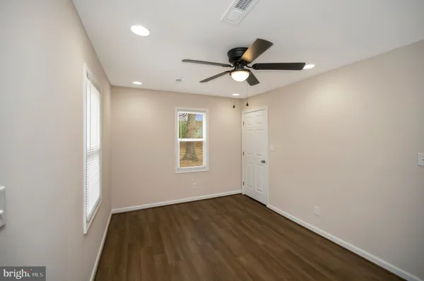 a view of a big room with wooden floor and windows