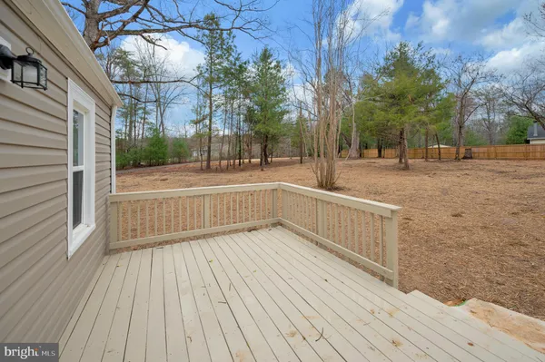 a view of backyard with deck and wooden floor