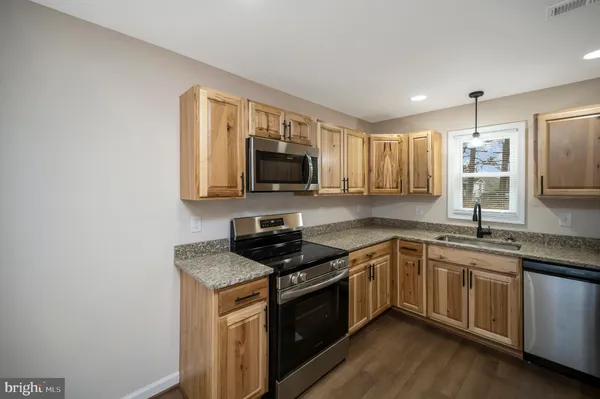 a kitchen with a sink stove and microwave