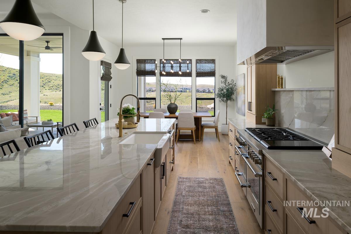 11415 North Misty Ridge Way Boise, ID 83714 - Photo 18 of 46 Kitchen with plenty of natural light, double oven range, premium range hood, and light stone countertops