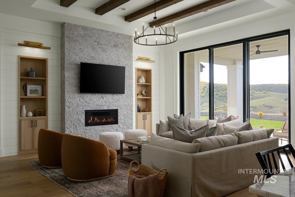 11415 North Misty Ridge Way Boise, ID 83714 - Photo 29 of 46 Living room featuring beamed ceiling, built in shelves, a fireplace, a chandelier, and wood finished floors