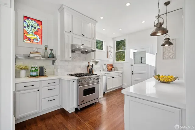 a kitchen with a refrigerator and a stove top oven