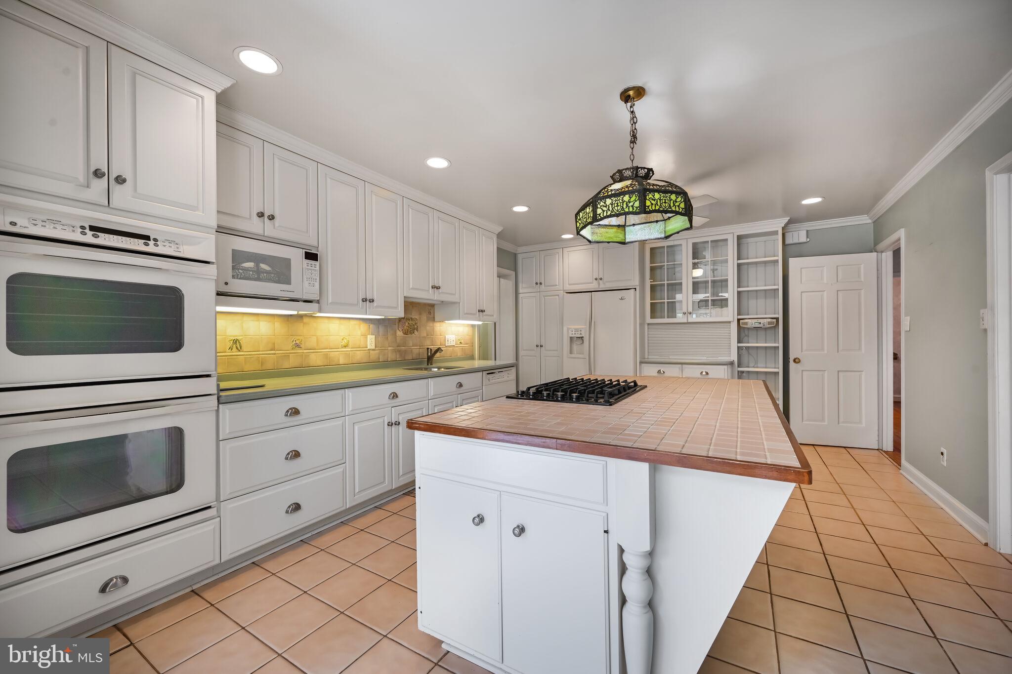 11337 Willowbrook Drive Rockville, MD 20854 - Photo 11 of 50 a kitchen with kitchen island granite countertop a stove a sink and a refrigerator