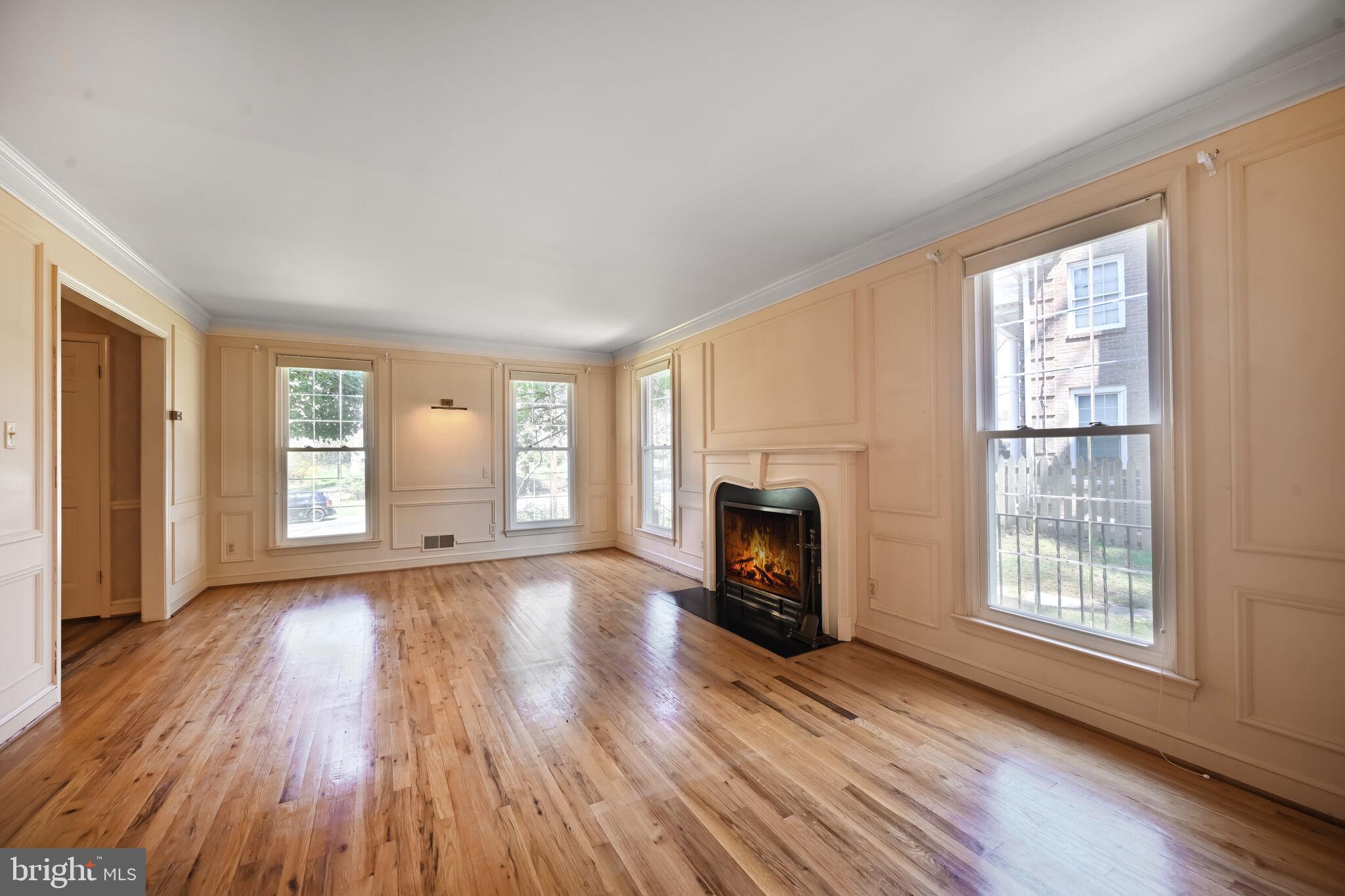 11337 Willowbrook Drive Rockville, MD 20854 - Photo 5 of 50 an empty room with wooden floor fireplace and windows