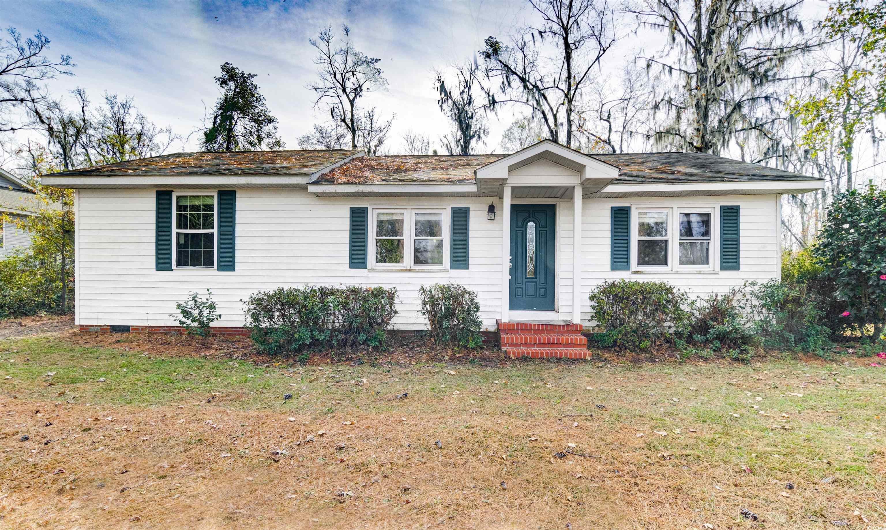 Single story home featuring a front lawn and a shingled roof