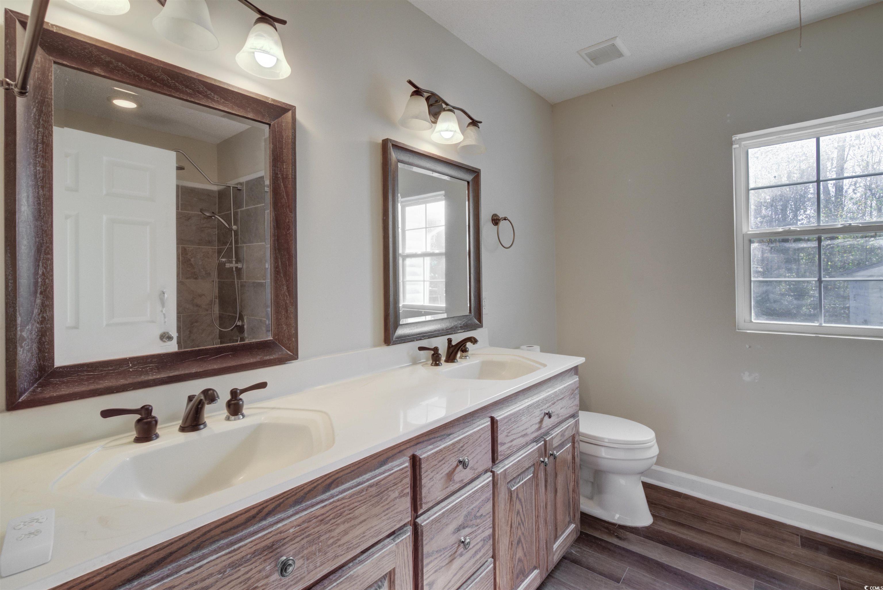2080 Highway 90 Conway, SC 29526 - Photo 26 of 29 Bathroom featuring tiled shower, double vanity, and dark wood-style floors