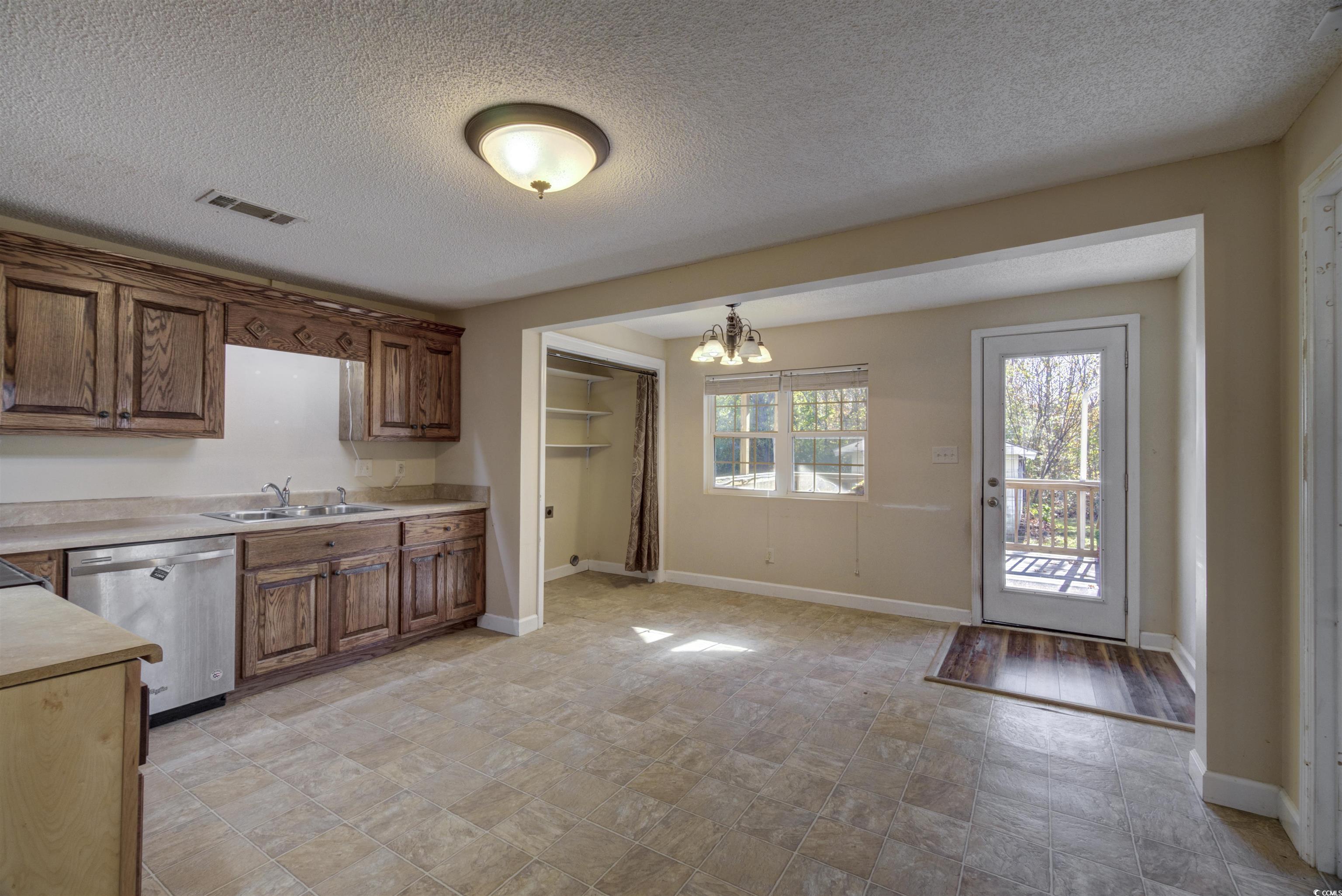 2080 Highway 90 Conway, SC 29526 - Photo 7 of 29 Kitchen with light countertops, dishwasher, a textured ceiling, a chandelier, and brown cabinetry