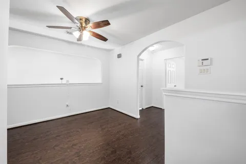 an empty room with a window and a ceiling fan