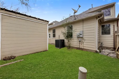 a view of backyard with barbeque grill and a large tree