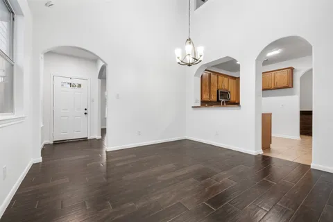 a view of empty room with wooden floor and window
