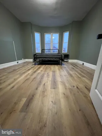 a view of a room with wooden floor and a window