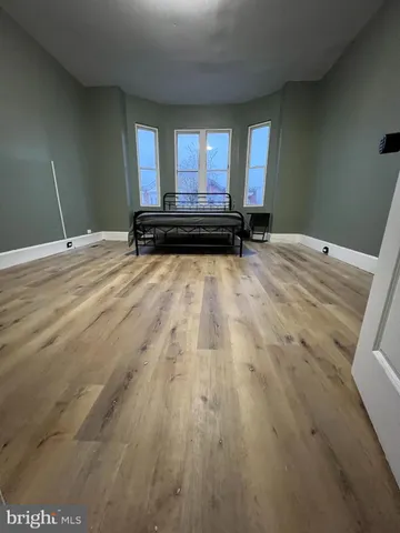 a view of a room with wooden floor and a window