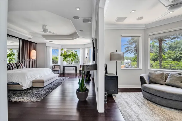 a bedroom with a bed a dresser and wooden floor