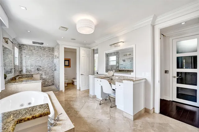 a kitchen with stainless steel appliances kitchen island granite countertop a table chairs in it and wooden floors