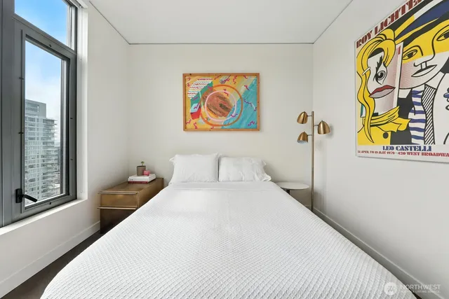 a bedroom with a bed and a large window