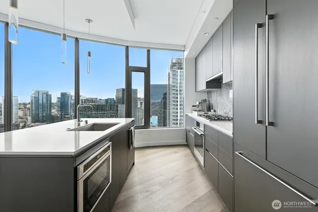 a large kitchen with kitchen island a large window cabinets and stainless steel appliances