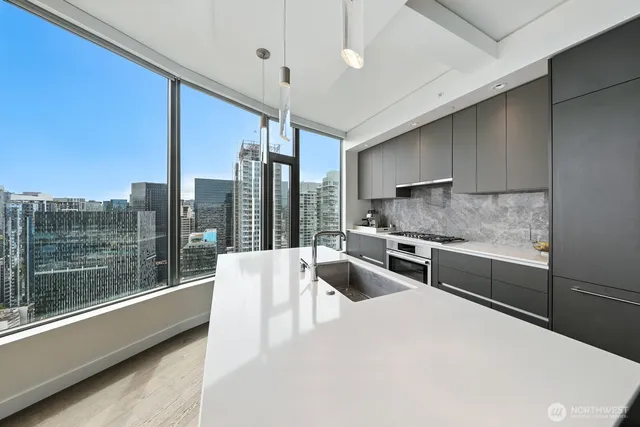 a kitchen with stainless steel appliances sink stove and cabinets