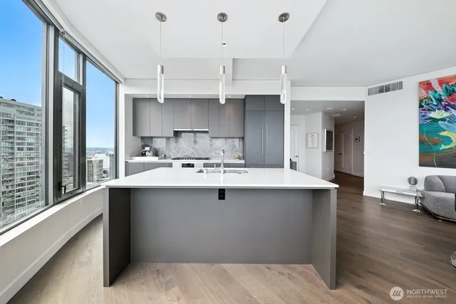 a kitchen with stainless steel appliances a sink dishwasher stove and oven with cabinets