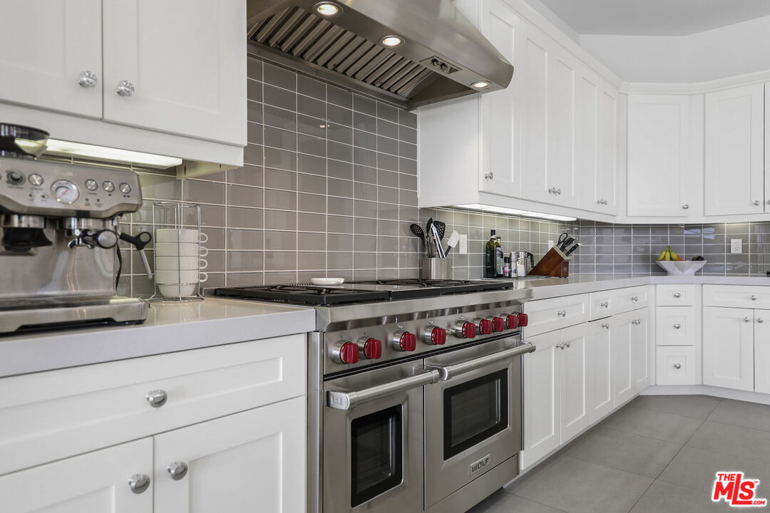 81805 Andalusia La Quinta, CA 92253 - Photo 13 of 45 a kitchen with stainless steel appliances granite countertop a stove a sink and white cabinets