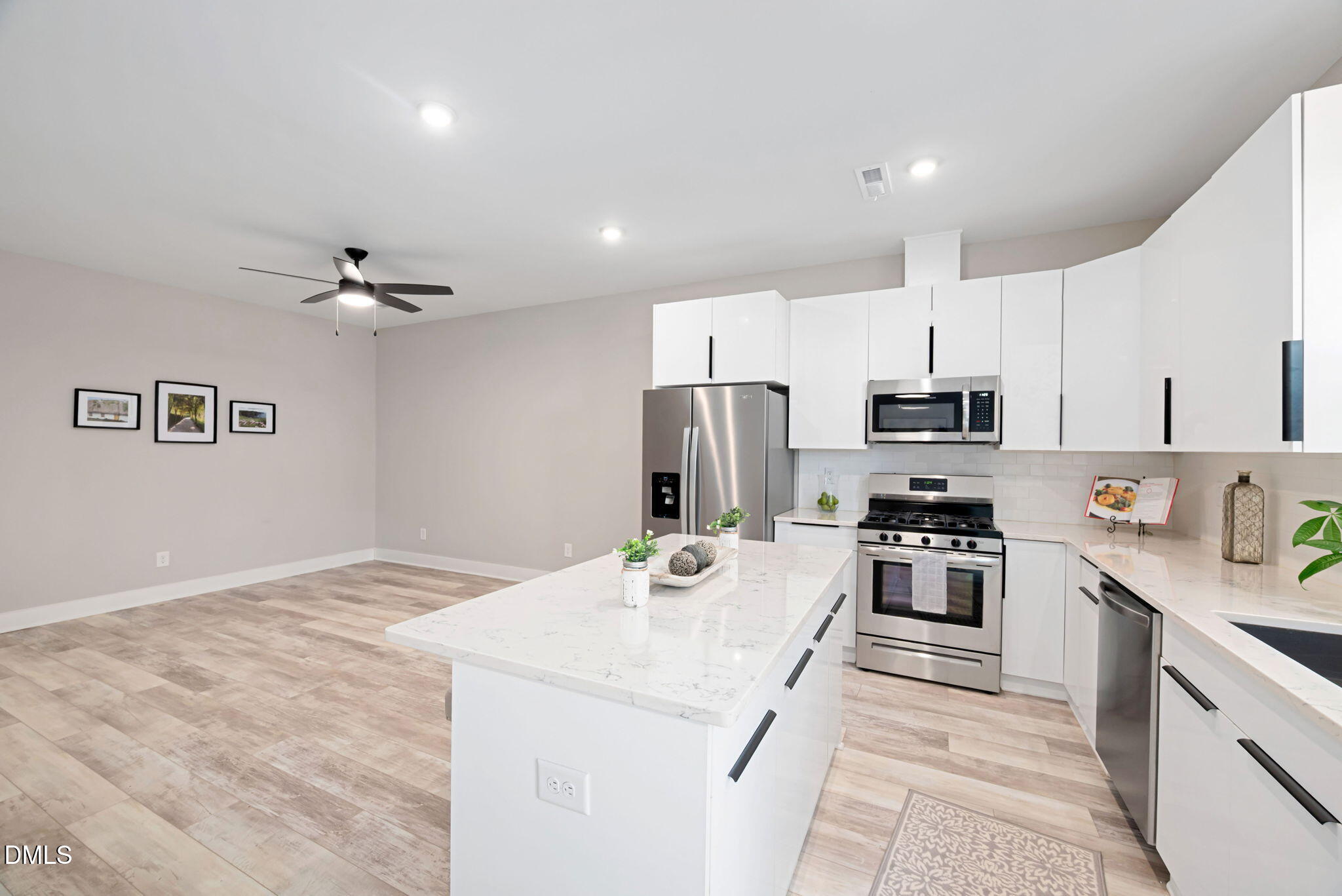 4208 Convergence Street Durham, NC 27704 - Photo 13 of 38 a kitchen with stainless steel appliances refrigerator stove microwave and cabinets
