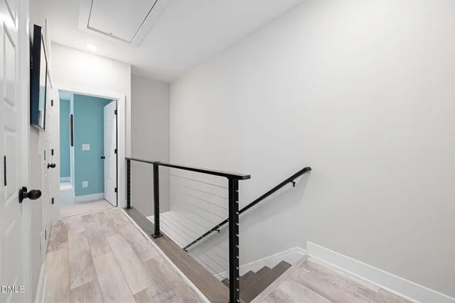 a view of a hallway with wooden floor and staircase