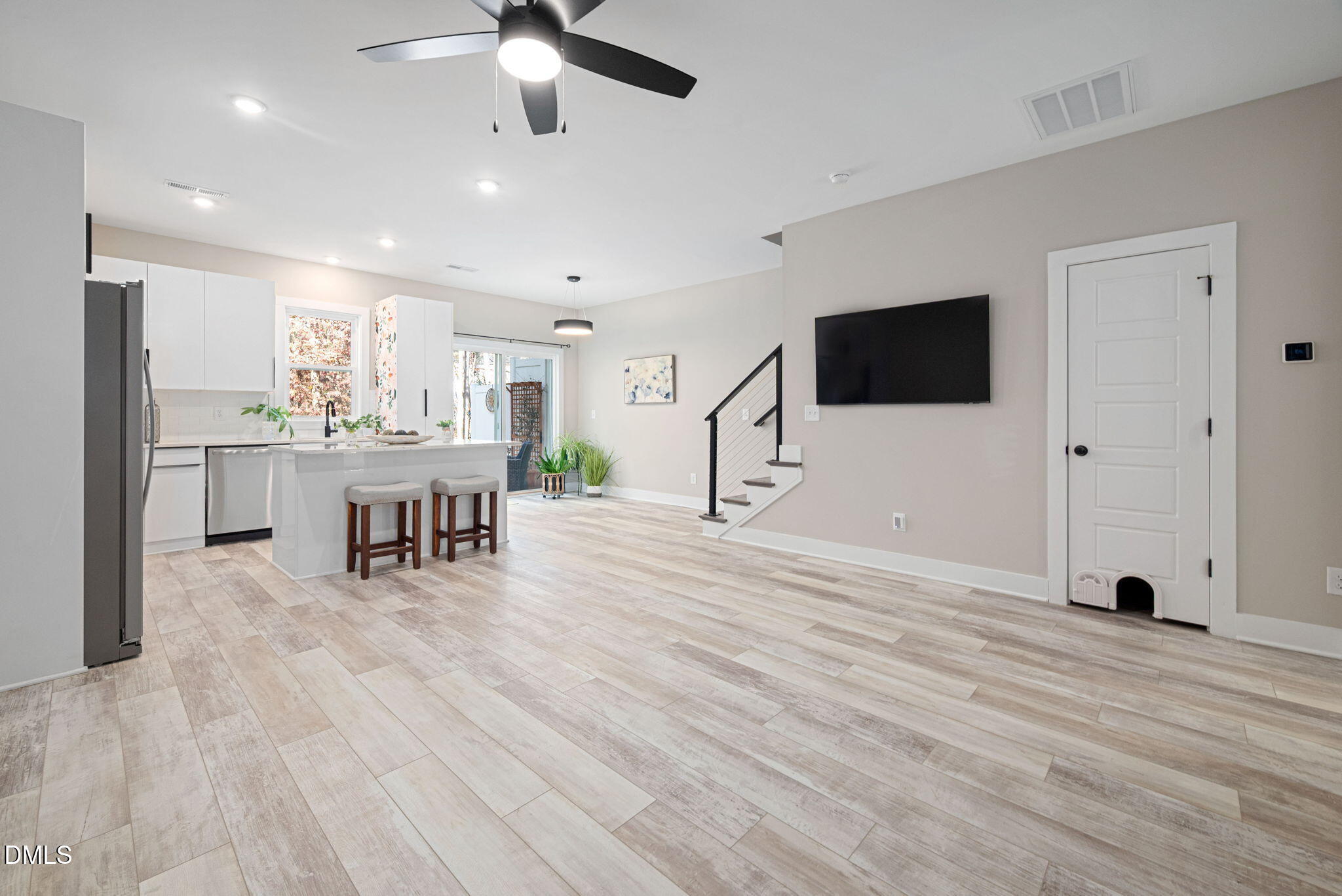 4208 Convergence Street Durham, NC 27704 - Photo 9 of 38 a view of a living room a dining room wooden floor and a ceiling fan