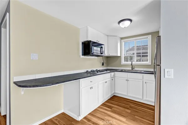 a kitchen with granite countertop white cabinets and a sink