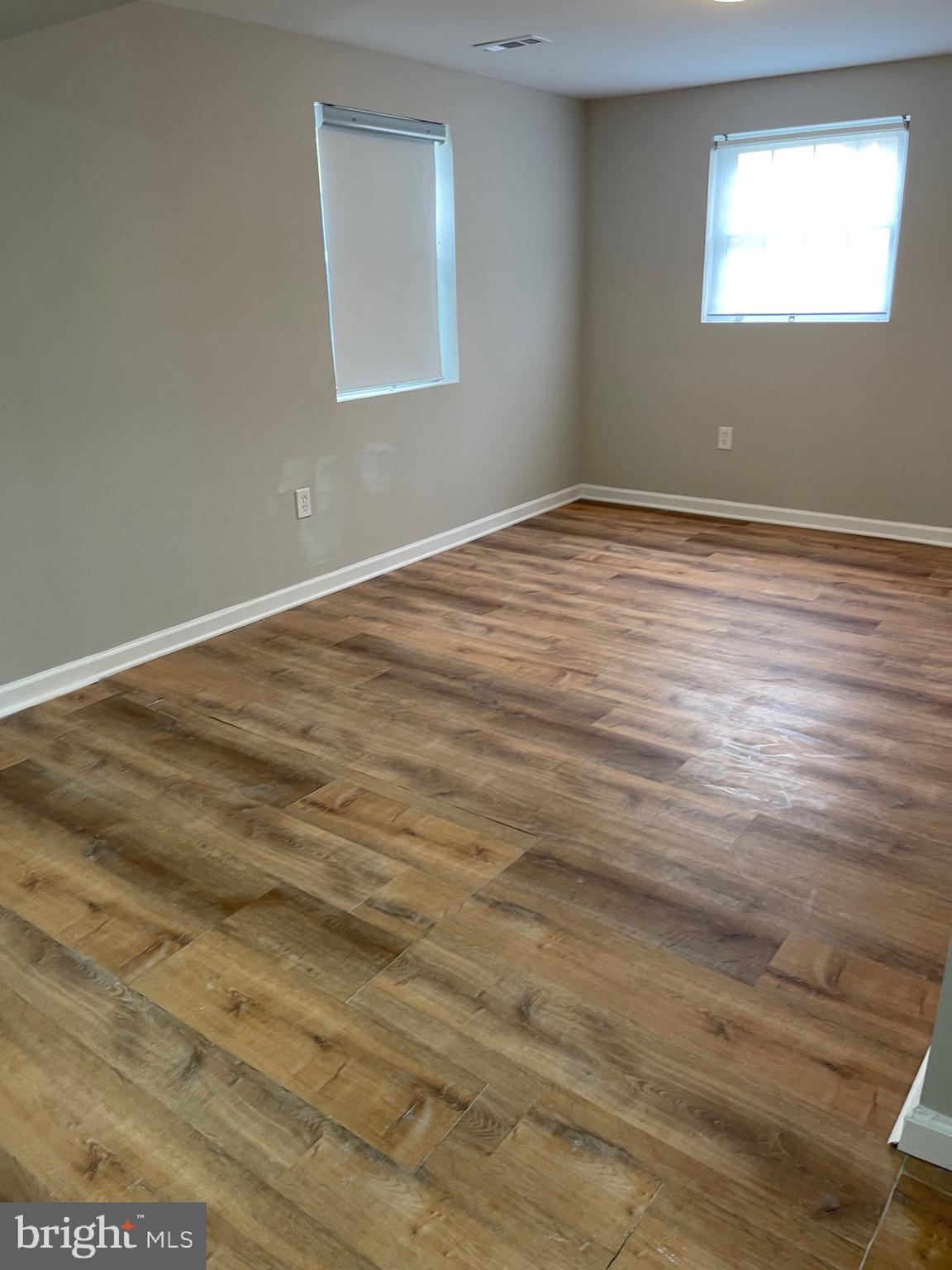 3207 # Road Beltsville, MD 20705 - Photo 22 of 25 a view of an empty room with wooden floor and a window