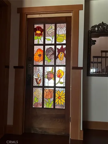 a view of a living room with a window and wooden floor