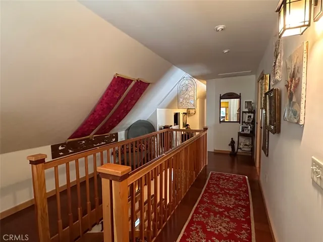 a view of a hallway with workspace and wooden floor