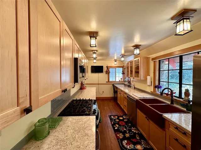 a large kitchen with a large window and stainless steel appliances