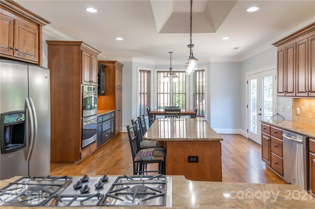6723 Fox Ridge Circle Davidson, NC 28036 - Photo 5 of 42 a living room with stainless steel appliances kitchen island granite countertop a refrigerator a stove a sink a dining table and chairs with wooden floor