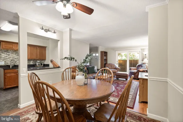 a dining room with wooden floor a chandelier a wooden table and chairs