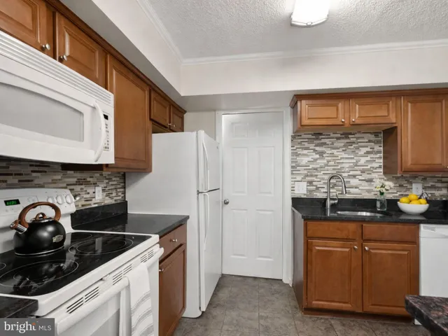 a kitchen with stainless steel appliances granite countertop a stove and a refrigerator