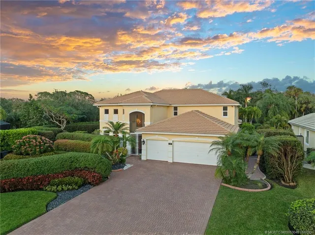 a view of house with a yard and potted plants