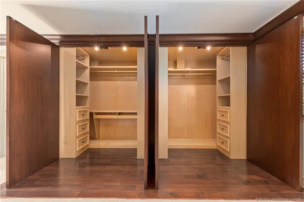 a view of walk in closet with wooden floor