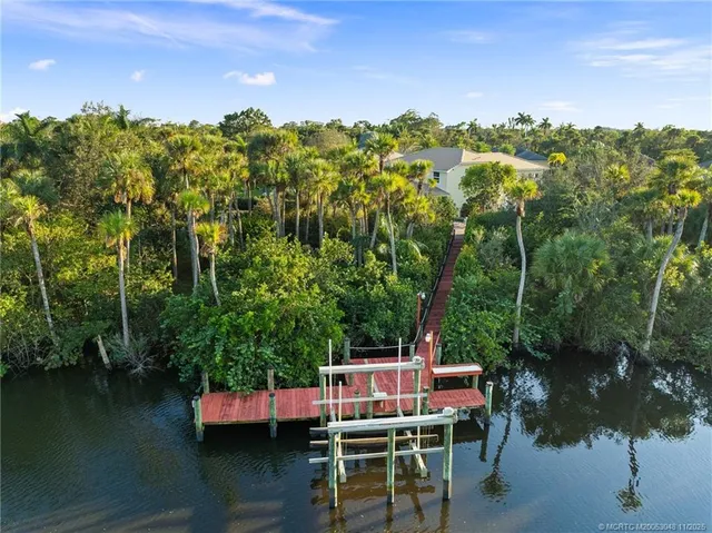 an aerial view of residential house with outdoor space and trees all around