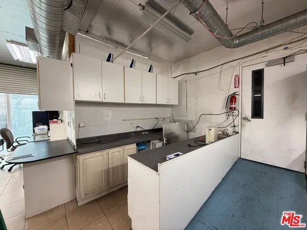 a kitchen with white cabinets and refrigerator