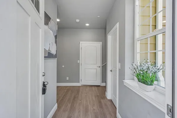 a view of a hallway with wooden floor and entryway
