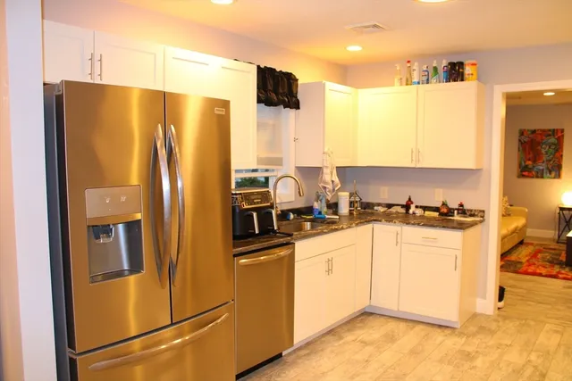 a kitchen with stainless steel appliances granite countertop a refrigerator a stove and a sink