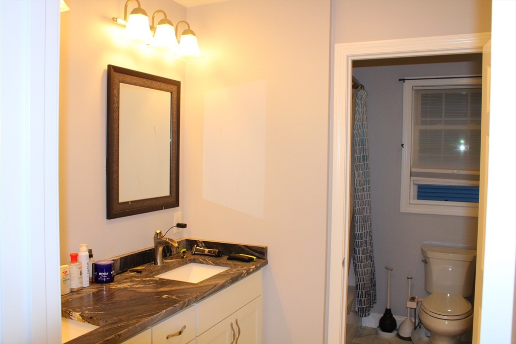 10 North Court Street, Unit 3 Fall River, MA 02720 - Photo 22 of 26 a bathroom with a granite countertop sink toilet and a mirror