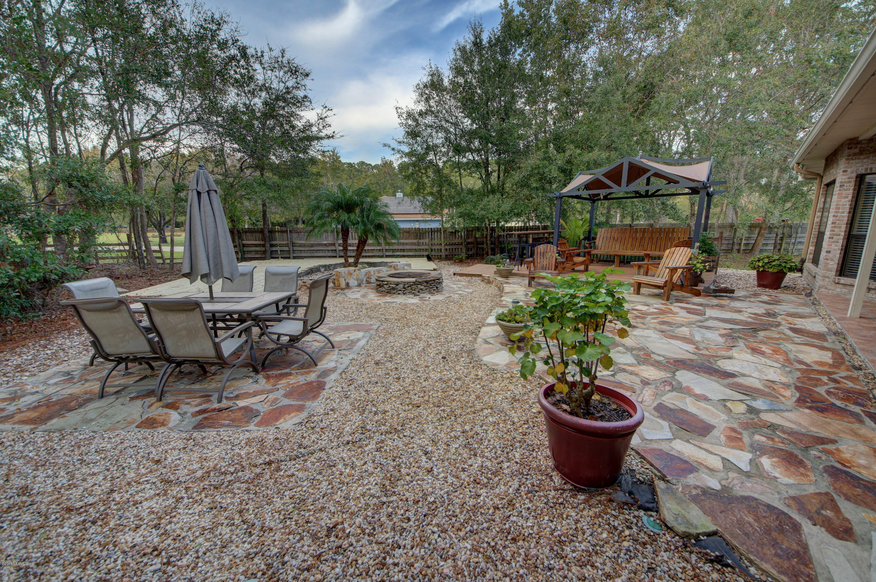 1302 Sinclair Lane Jacksonville, FL 32221 - Photo 29 of 32 a view of a backyard with table and chairs potted plants